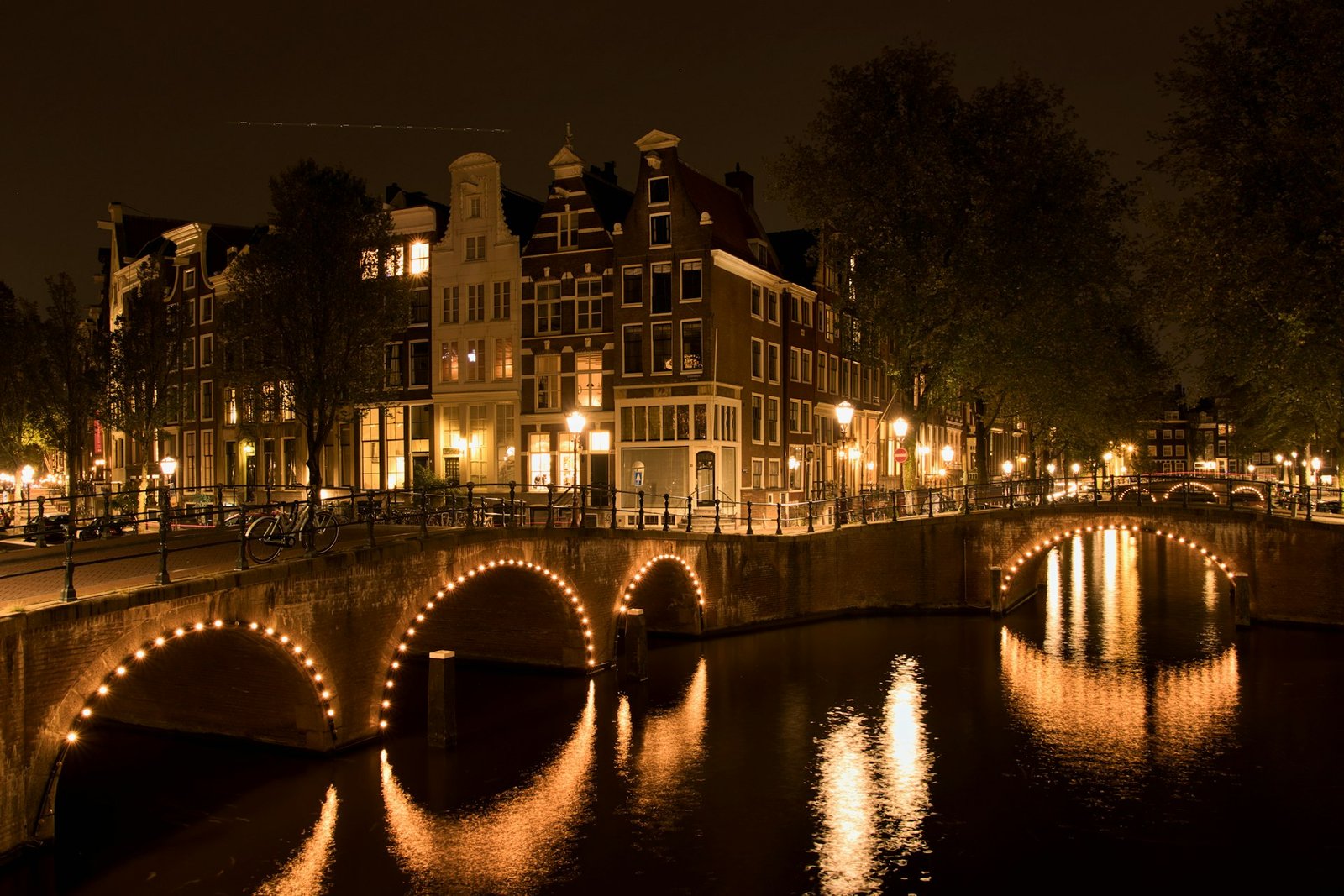 Amsterdamse grachten en gebouwen verlicht in de avond